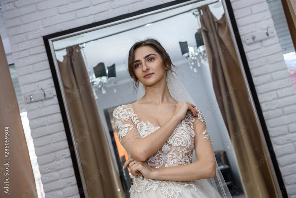 Beautiful bride in salon posing in wedding dress Beautiful bride in salon posing in wedding dress