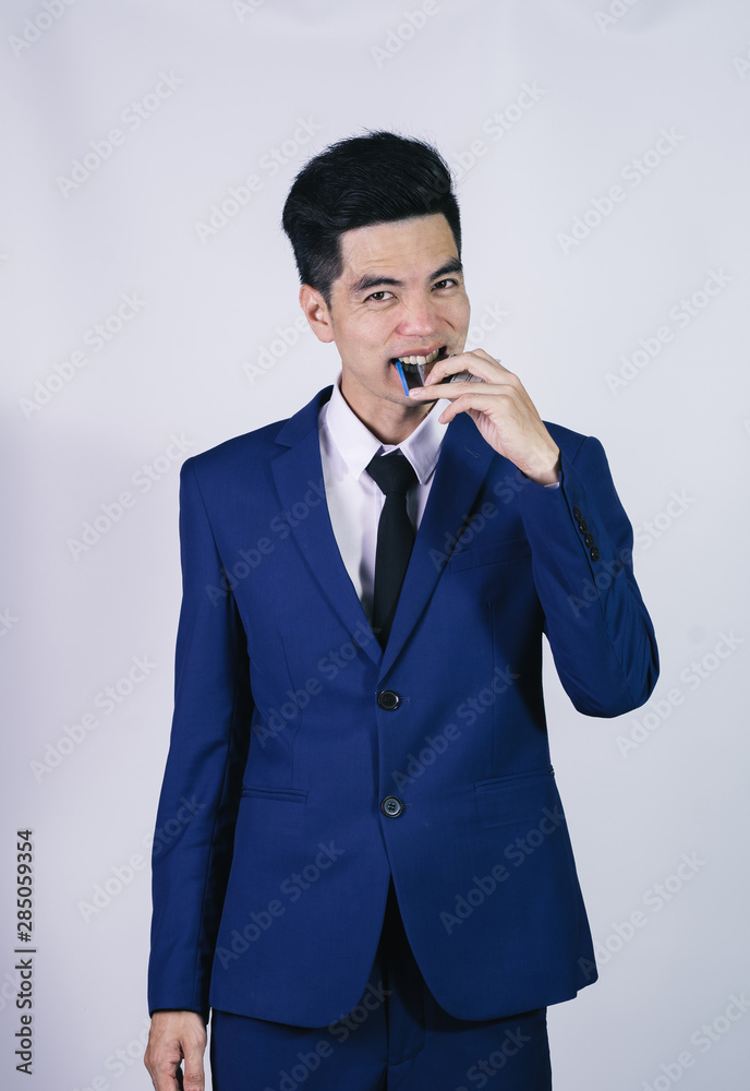 Portrait handsome young asian man wearing a blue shirt holding credit card and stressful isolated on white background. Asian man people. business success concept. Portrait handsome young asian man wearing a blue shirt holding credit card and stressful isolated on white background. Asian man people. business success concept.