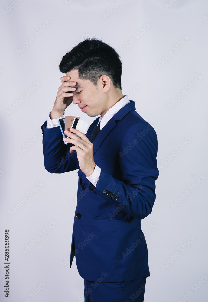 Portrait handsome young asian man wearing a blue shirt holding credit card and stressful isolated on white background. Asian man people. business success concept. Portrait handsome young asian man wearing a blue shirt holding credit card and stressful isolated on white background. Asian man people. business success concept.