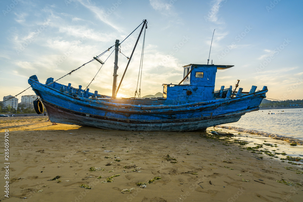 Beautiful sunrise on an old wooden fishing boat on the beach Beautiful sunrise on an old wooden fishing boat on the beach