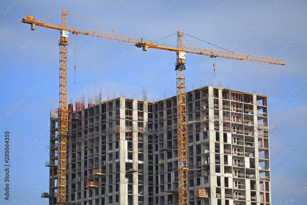 Building construction site with cranes. High-rise buildings and construction cranes. Buildings under construction