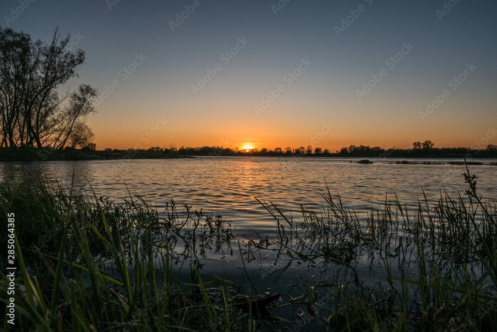 view of the setting sun over the river water view of the setting sun over the river water