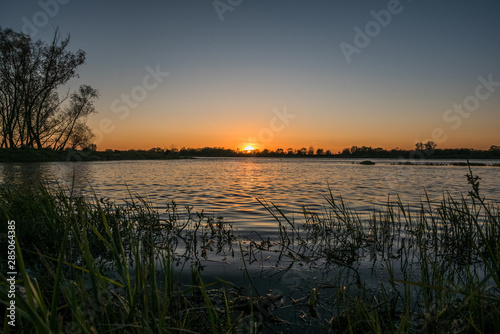 Fototapeta Naklejka Na Ścianę i Meble -  view of the setting sun over the river water