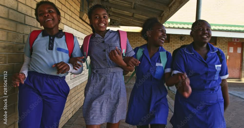 Schoolgirls running in the playground at a township school 4k