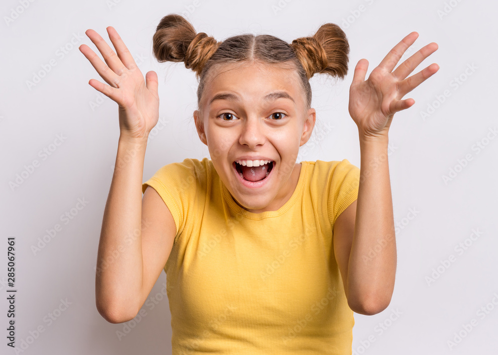 Portrait of joyful or surprised teen girl with raised hands. Beautiful  caucasian teenager laughing and screaming on gray background. Happy child  exclaiming with joy and excitement, looking at camera Stock Photo |
