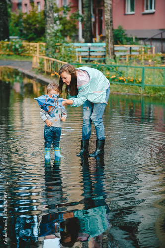 Mom helps reveal umbrella to her little son. photo