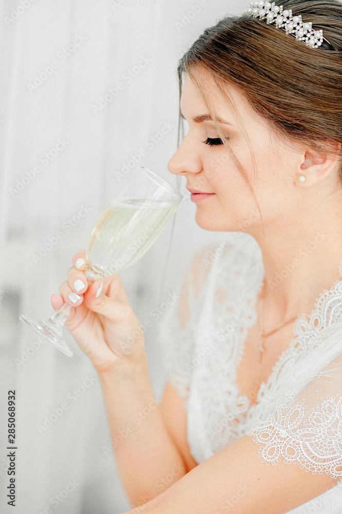 Morning bride, beautiful fair-haired bride is preparing for the wedding in boudoir lingerie in the white room Morning bride, beautiful fair-haired bride is preparing for the wedding in boudoir lingerie in the white room
