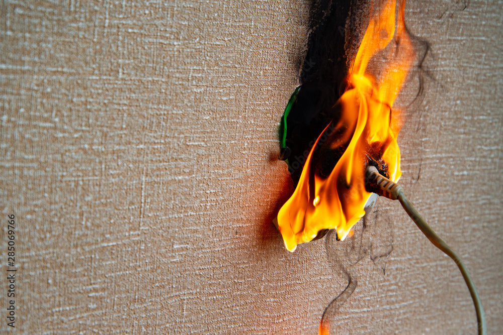 Foto de Burning electrical wiring and electrical outlet. Faulty wiring ...