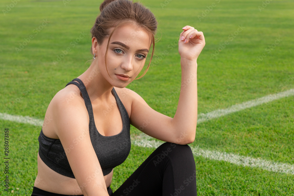 sexy athletic girl sitting on grass in a stadium sexy athletic girl sitting on grass in a stadium