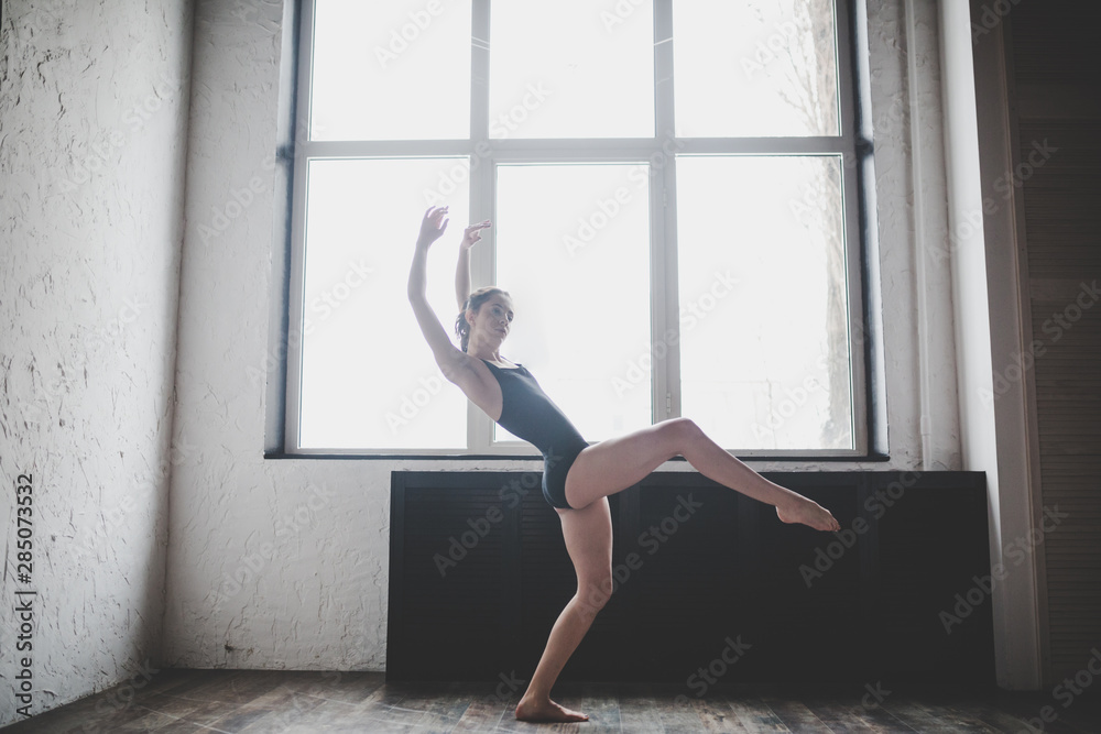 Plasticity slim woman dancing near window. Professional dancer enjoy dance. Lady Dancer Training Modern Ballet In Class. Contemporary dance performer. Daylight, silhouette beautiful body. Dance theme