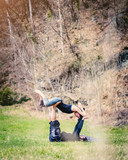  Giovane coppia pratica acroyoga e yoga all'aperto in montagna al parco