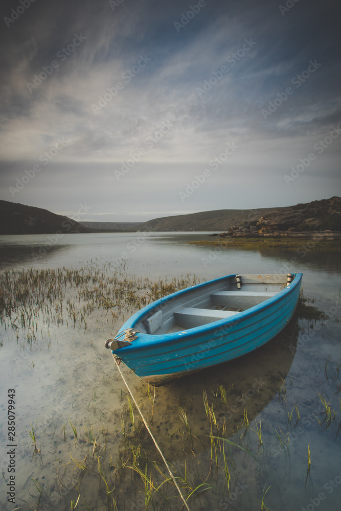 Wide angle landscape image of an old fishing boat in an estuary in South Africa