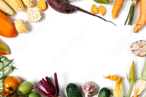 Pattern made of autumn vegetables. Food concept. Tomatoes, onion, cucumber, carrot, garlic, red beet, pepper, zucchini, maize and green haricot on white background. Flat lay, top view, copy space