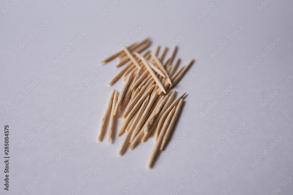 Wooden toothpicks lie in different forms on the table. Wooden toothpicks lie in different forms on the table.