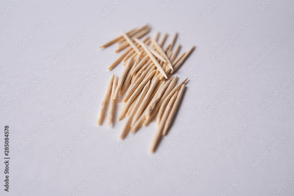 Wooden toothpicks lie in different forms on the table. Wooden toothpicks lie in different forms on the table.