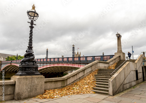 A large pile of fallen leaves at the stairs to Lambeth Bridge in London, England photo