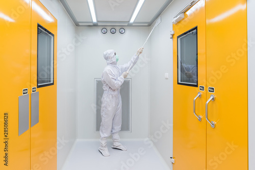 Картината върху платно A scientist in sterile coverall gown using Cleaning tool for cleaning laboratory