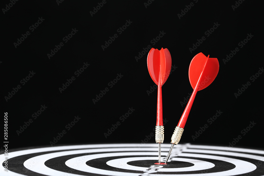 Dartboard with darts on black background Dartboard with darts on black background