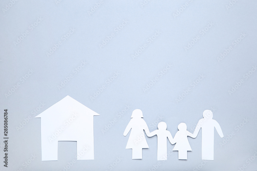 Paper family figures and house on grey background Paper family figures and house on grey background