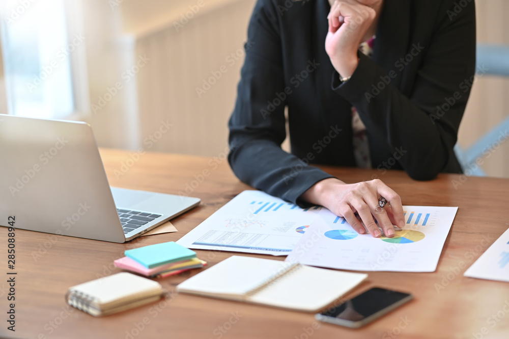 Female audit analysis finance data in paper document on working table. Female audit analysis finance data in paper document on working table.