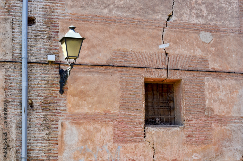 Black lantern on old brick wall whit window