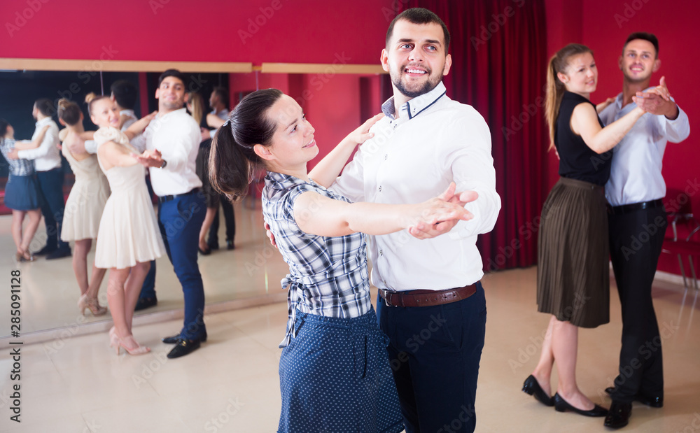 Young dancing couples enjoying foxtrot