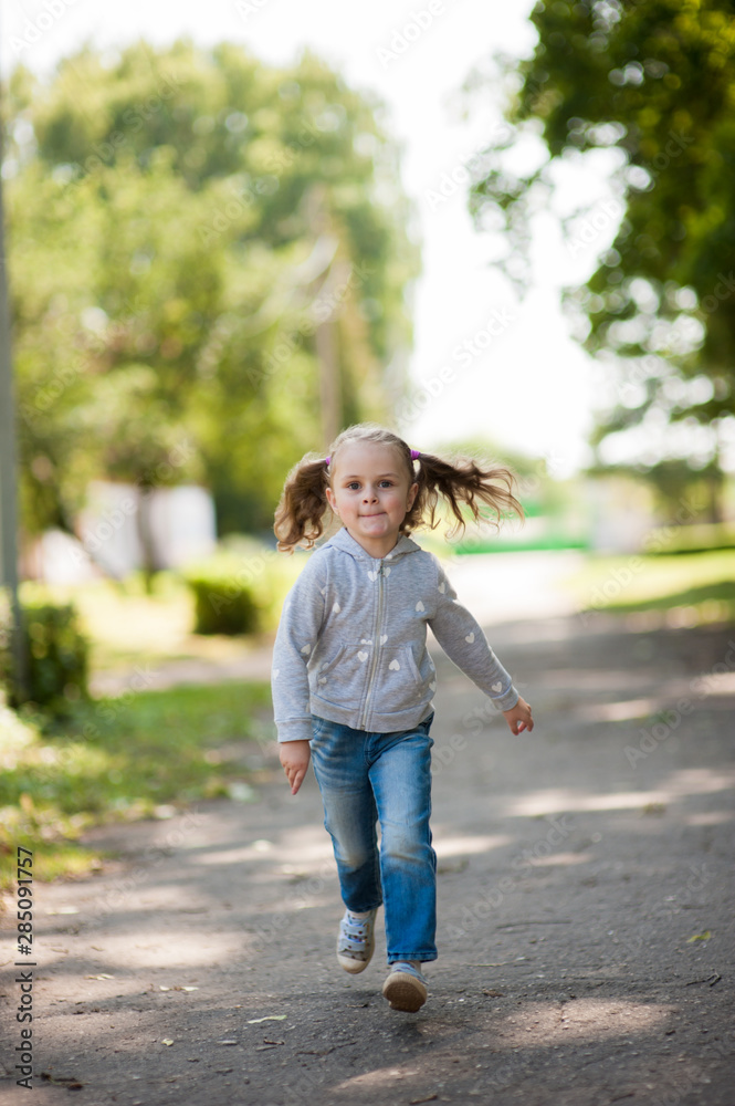 Portrait of a little girl running in a park Portrait of a little girl running in a park