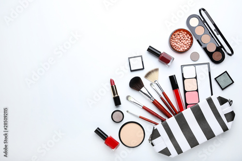 Makeup brushes and different cosmetics on white background