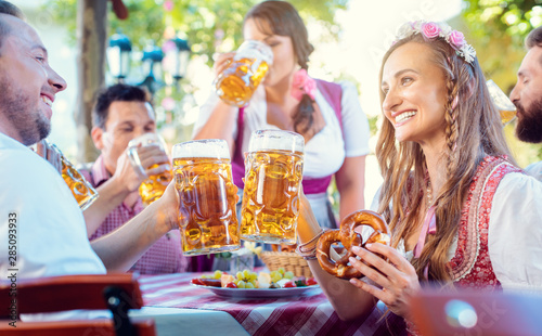 Couple clinking glasses with huge amounts of beer in Bavarian pub photo