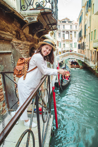 portrait of smiling woman looking at canal with gandola