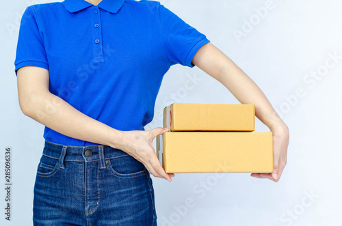 Asian women in a blue shirt. she smiled and held several brown boxes at the same time isolated white background.Women send parcels. © Siriluk