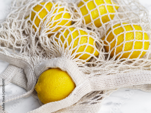 Fototapeta Naklejka Na Ścianę i Meble -  High angle crochet net bag with lemons