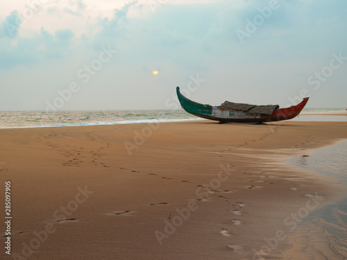 traditional Indian fisherman boat on a golden sandy beach at dawn