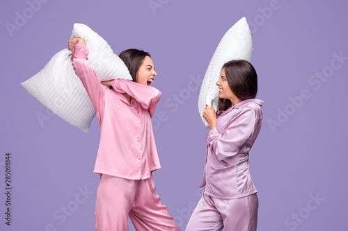 Canvas Print Young women having pillow fight during sleepover