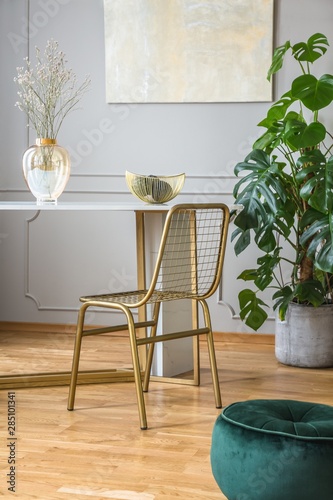Fancy golden chair at small dining table in chic living room