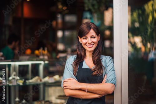 Foto Portrait of a beautiful positive waitress standing in the doorway
