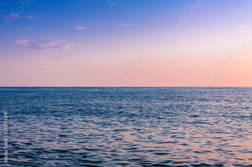 Picturesque sunset over the blue surface of the sea.