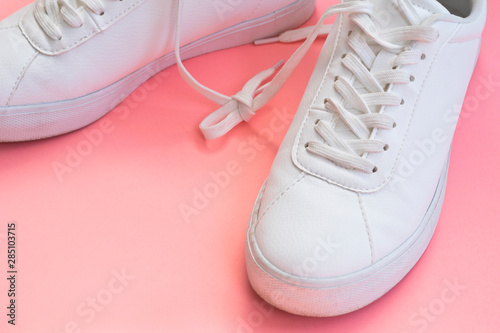 Fashion blog or magazine concept. White female sneakers on wooden background.