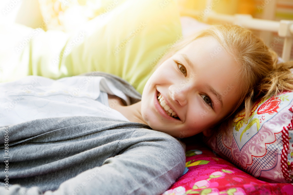 Smiling girl lying on bed, portrait Smiling girl lying on bed, portrait
