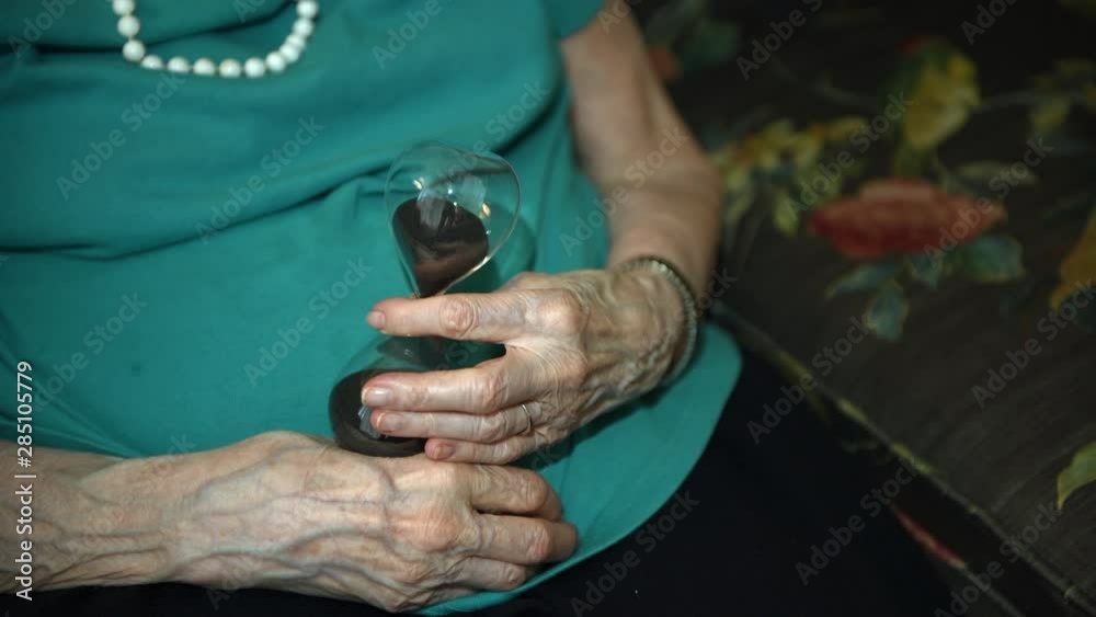 Elderly woman holding on to time as it slips away
