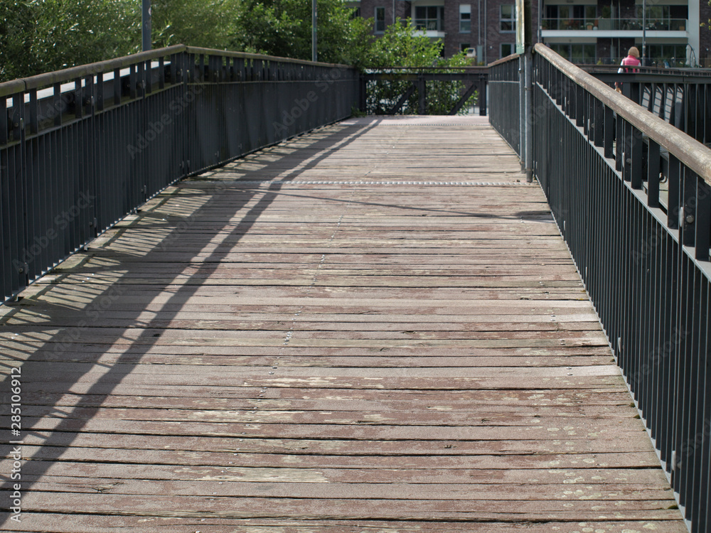Wooden bridge with metal railing leading over the river Ruhr