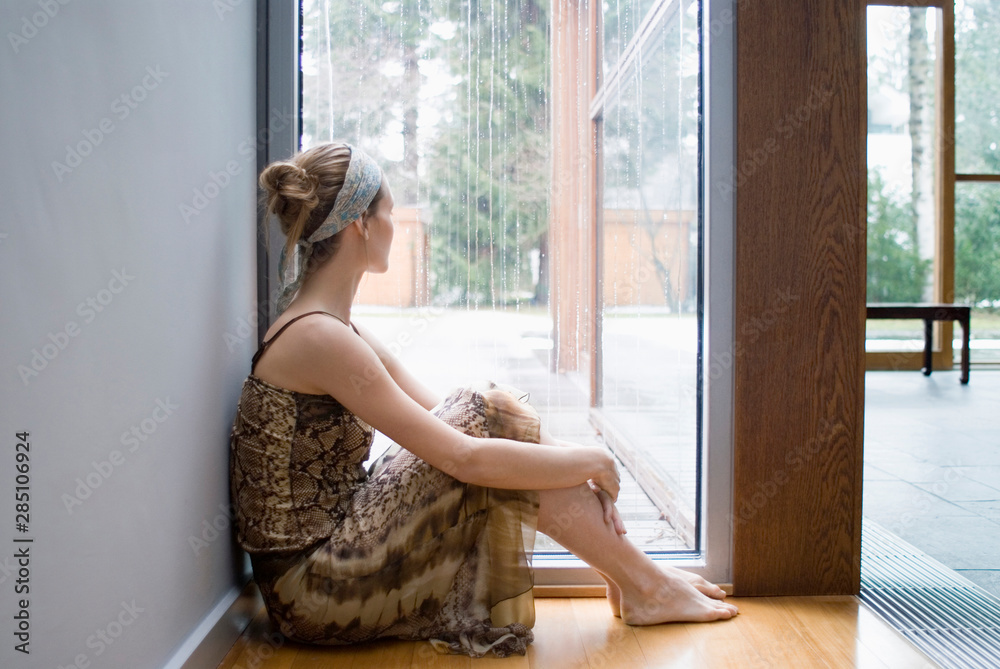 Ballerina sits on floor looking out of window Ballerina sits on floor looking out of window