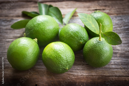 Fresh limes on old wooden background. With dark vignette. Favorite vegetable for sour taste.