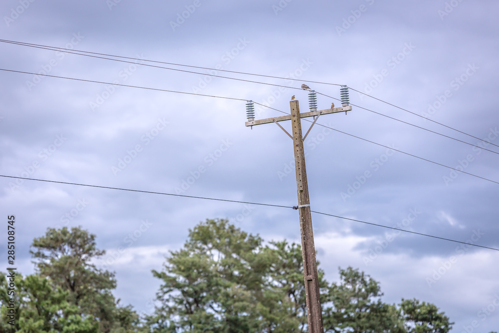 Rustic electrical pole with in a cloud sky day in Brazil