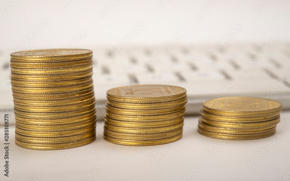 Gold coins stacks with keyboard digital economy concept