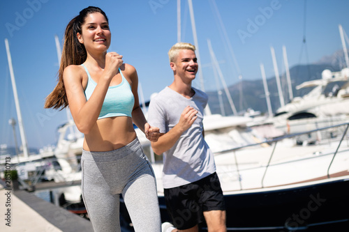Cheerful fit couple training on the beach. Sport concept