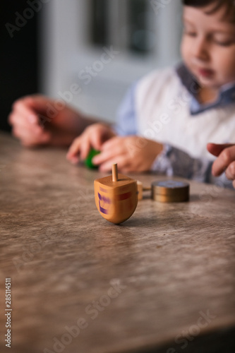 Hanukkah: Boy And Parent Playing Dreidel photo