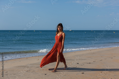 Young woman walking nude foots on the sand of the beach. Joy and freedom concept..