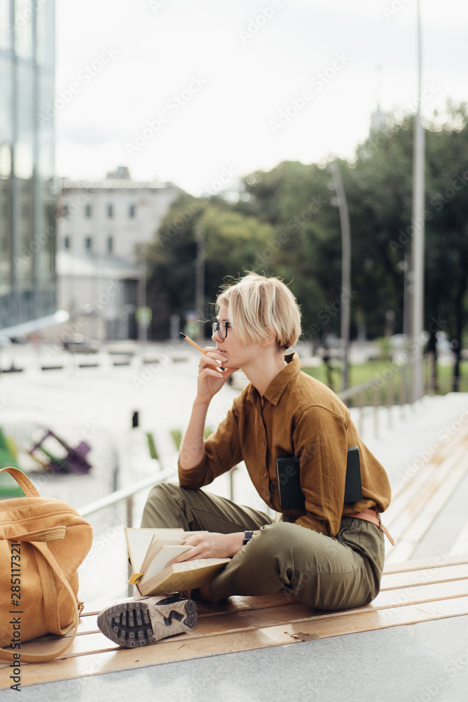 Woman with backpack and studies on bench Woman with backpack and studies on bench