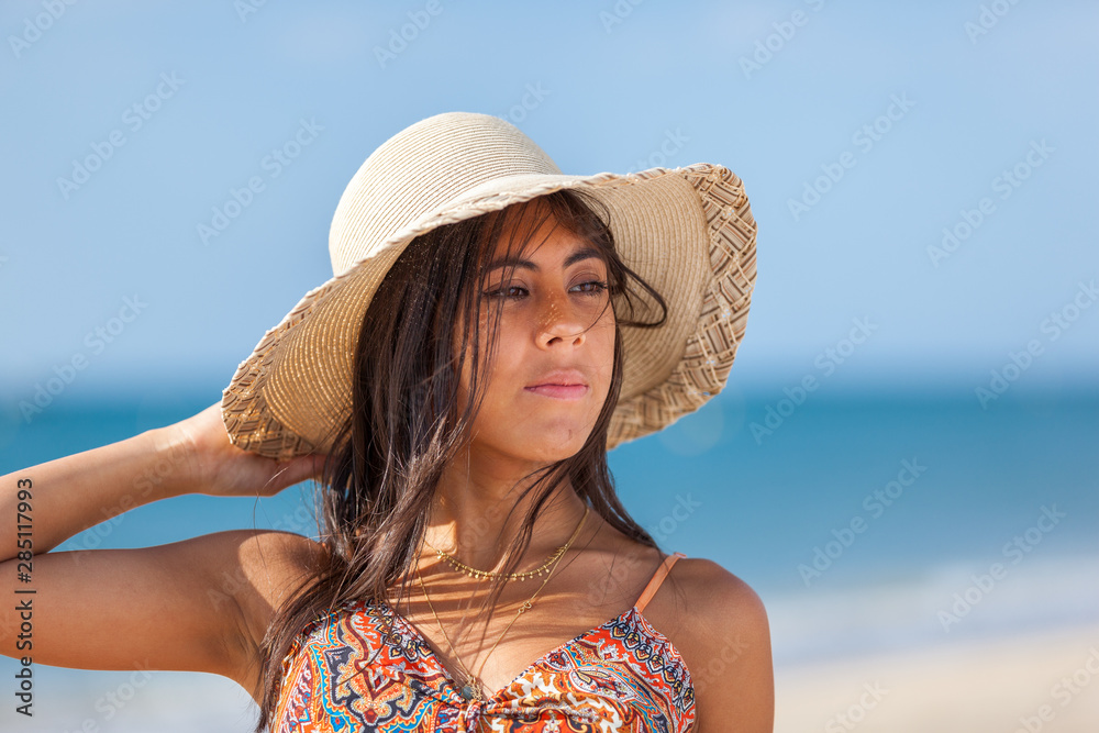 Portrait fashion of pretty young woman with straw hat on a beach. Happy Smiling girl..